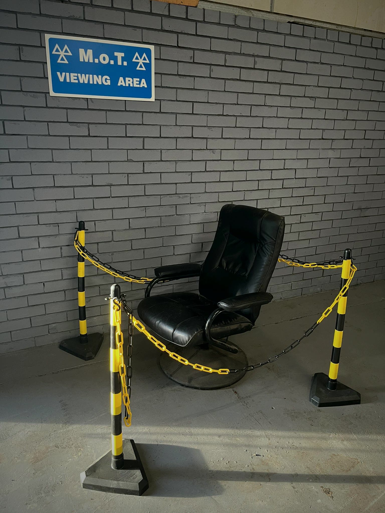 The MOT viewing area in our Unit 2 test centre: a chair behind a chain barrier under the M.o.T. Viewing Area sign.
